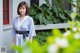 A woman in a blue and white kimono standing in front of a building.