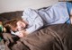 A young girl laying on a bed with her head on a pillow.