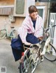 A woman sitting on a bicycle in front of a building.