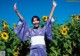 A woman in a blue kimono standing in a field of sunflowers.