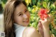 A young woman holding a red flower in her hand.