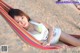 A woman laying in a hammock on the beach.