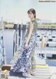 A woman standing on a dock next to a body of water.