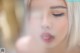 A close up of a woman blowing a kiss.