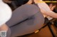 A woman in gray leggings is getting her butt examined by a doctor.