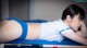 A woman laying on top of a pool table next to a pool cue.