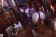 A woman in a purple outfit is posing on a wooden floor.