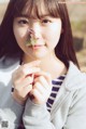 A young woman holding a leaf in her hand.